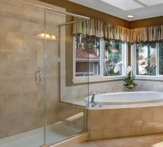 Frameless glass shower enclosure beside a soaking tub